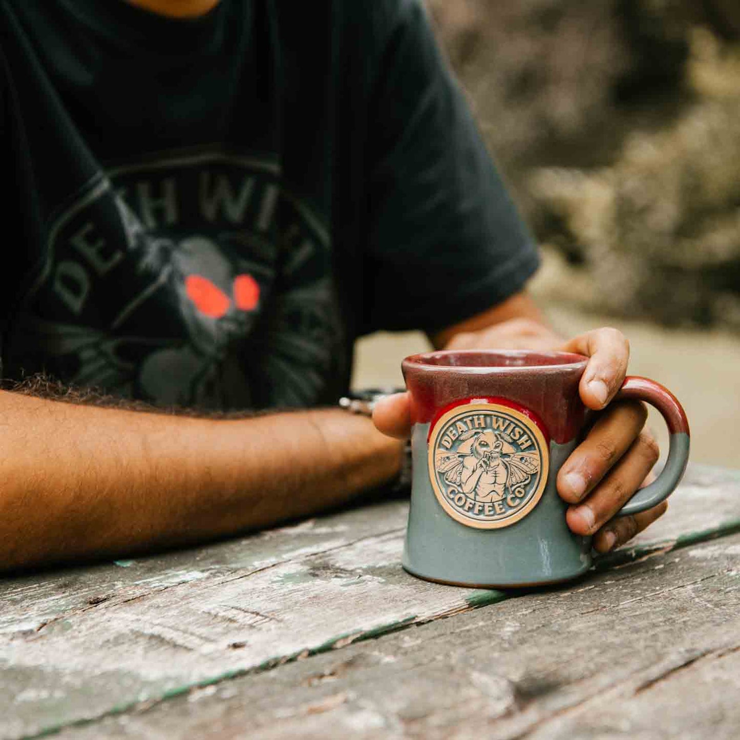 Gripping the Death Wish Coffee Mothman Mug.