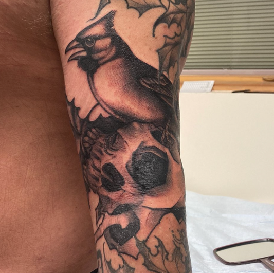 A picture of a skull and raven tattoo done by Peter Clarke of Dead Presidents Lounge.