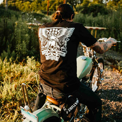 Riding a motorcycle in the Death Wish Coffee Rebellious by Nature Pocket Tee.