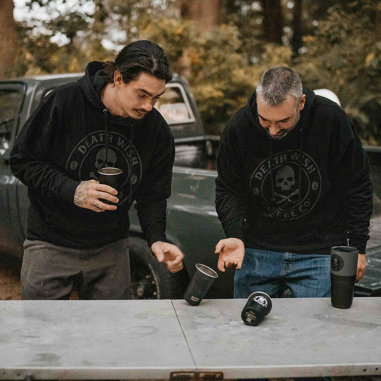 Two guys playing flip cup with coffee and the Death Wish Coffee Camping Bundle.