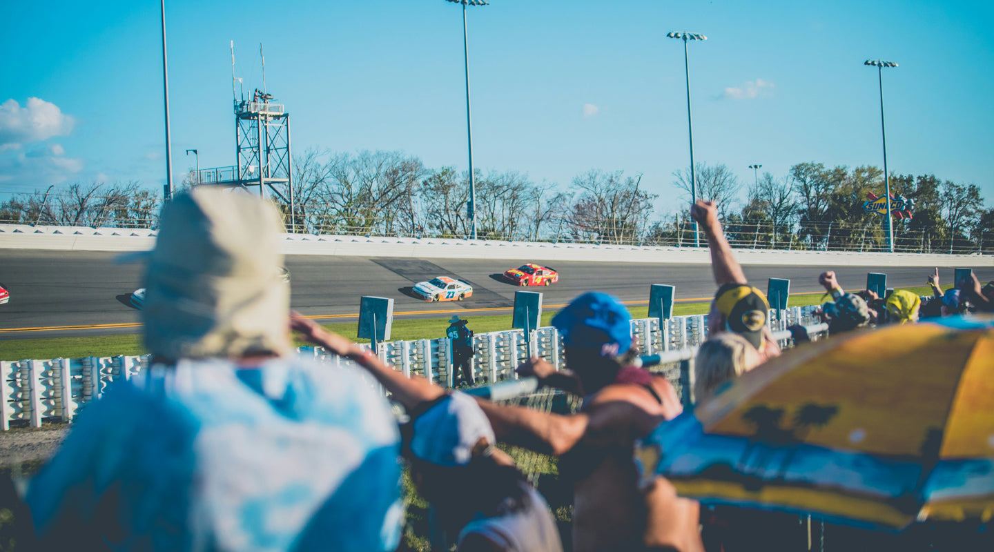 NASCAR fans cheer on their favorite drivers at the Daytona 500. [Image Credit: Tim Trad via Unsplash]